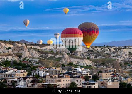 GOREME/TÜRKEI - 27. Juni 2022: Heißluftballon fliegt über die Stadt goreme Stockfoto