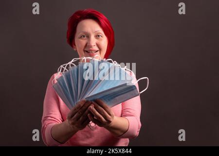 Eine Frau hält medizinische Schutzmasken in ihren Händen Stockfoto