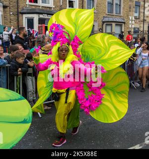 Frau in buntem Blumenkostüm in Leeds West Indian Carnival Parade Stockfoto