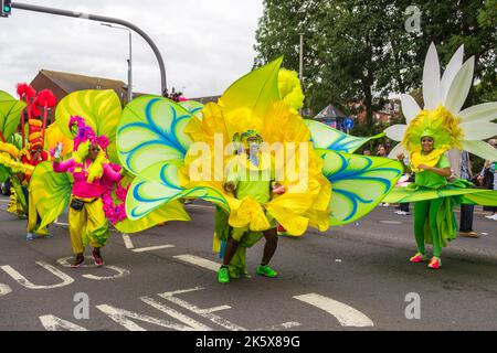 Frauen in riesigen Blumenkostümen in Leeds West Indian Carnival Parade Stockfoto