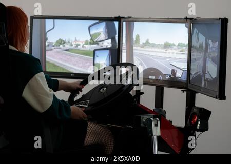 Polen, Poznan - 09. Oktober 2022: Poznan Game Arena, eine Videospiel-Messe. Mädchen spielt Autosimulator Stockfoto