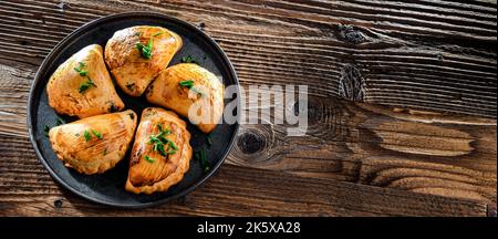 Zusammensetzung mit einem Teller aus im Ofen gebackenen Pierogi Stockfoto