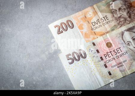Banknoten von 200 und 500 tschechischen Kronen auf grauem Hintergrund, Platz für Text, tschechisches Wirtschaftsfinanzkonzept Stockfoto