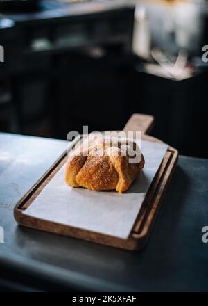 Eine vertikale Aufnahme des traditionellen mexikanischen Pan de Muerto auf einem Holzbrett Stockfoto