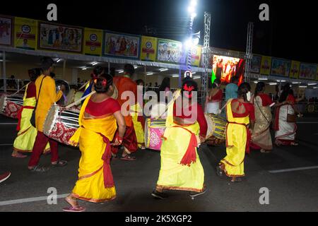 Rote Straße in Kalkutta Westbengalen, Indien am 8.. Oktober 2022 - Stammesleute genießen die Prozession des Durga Puja Karnevals Stockfoto