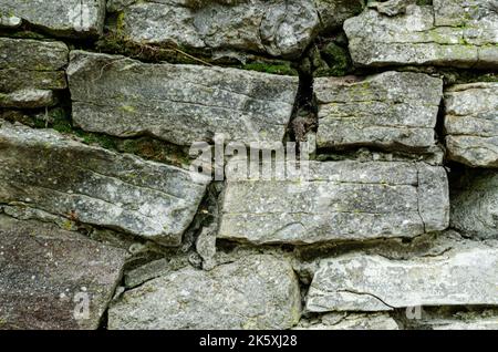 Muster graue Farbe des modernen Stils Design dekorativ ungleichmäßig geknackt echten Stein Wand Oberfläche Hintergrund mit Stein Textur Stockfoto