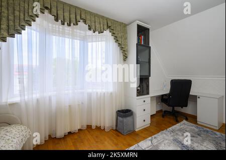 Innenraum eines großen, hell erleuchteten, komfortablen Schlafzimmers mit häuslichem Arbeitsplatz Stockfoto