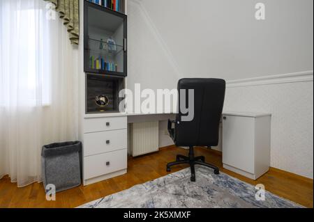 Innenraum eines großen, hell erleuchteten, komfortablen Schlafzimmers mit häuslichem Arbeitsplatz Stockfoto