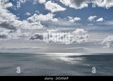 Endloser Meerblick, helles Sonnenlicht und Wolken Stockfoto