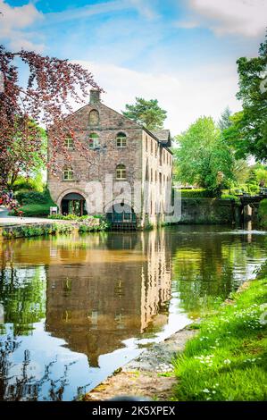 Eine vertikale Nahaufnahme eines alten Hauses neben einem See, umgeben von grünen Bäumen Stockfoto