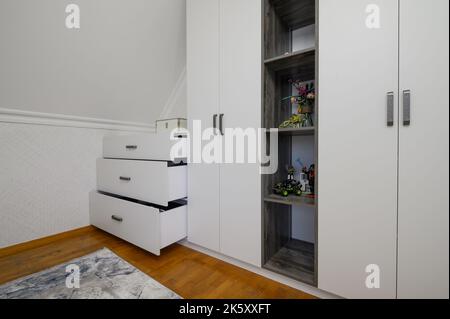 Großer weißer Schrank im Wohnzimmer mit Holzboden Stockfoto