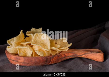 Nahaufnahme gebratener Linsen-Chips auf Schwarz Stockfoto