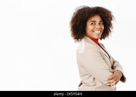 Porträt einer lächelnden afroamerikanischen Geschäftsfrau, einem Angestellten im Anzug, halb gedreht stehend, professionell aussehend, auf weißem Hintergrund stehend Stockfoto
