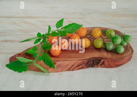 Rote Tomaten verzweigen sich auf dem Tischhintergrund, gesundes Essen Stockfoto