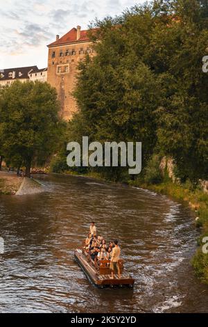 Menschen auf Holzfloß (vor) auf der Moldau in der historischen Stadt Cesky Krumlov. Wassersport (voroplavba) auf der Moldau. Lachende Touristen Stockfoto