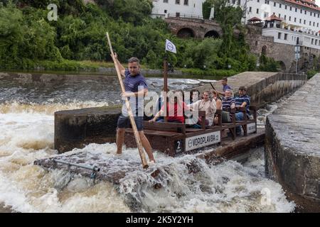 Menschen auf Holzfloß (vor) auf der Moldau in der historischen Stadt Cesky Krumlov. Wassersport (voroplavba) auf der Moldau. Lachende Touristen Stockfoto