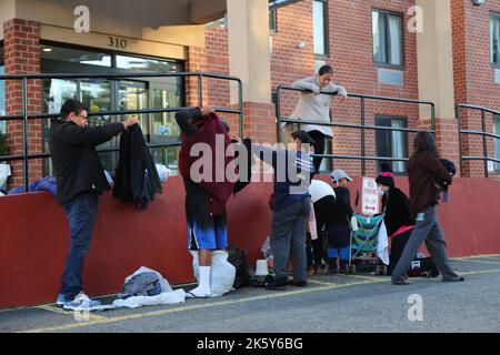 New York, USA. 9. Oktober 2022. Antonio Ovando (1. l), ein Asylbewerber, der vor weniger als einer Woche in New York City ankam, holt am 9. Oktober 2022 vor einem Hotel in Staten Island, New York, USA, Kleidung ab, die von New Yorkern abgesetzt wurde. Die Tausenden von neu angekommenen Asylbewerbern in New York City, der bevölkerungsreichsten Stadt der Vereinigten Staaten, stehen vor vielfältigen Herausforderungen, sich inmitten einer anhaltenden humanitären Krise zu verwurzeln. Quelle: Liu Yanan/Xinhua/Alamy Live News Stockfoto