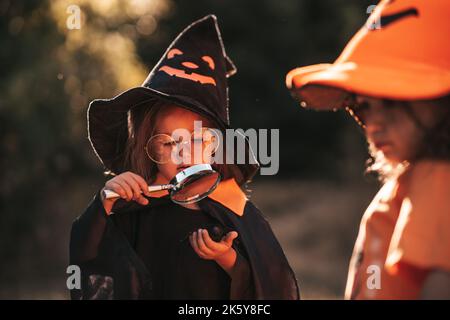 Zwei kleine Mädchen von drei Jahren feiern Halloween in der Natur Stockfoto