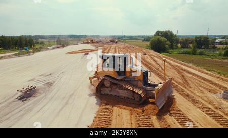 Oberflächengitter. Ein Bulldozer, Straßenbaumaschinen bewegt den Boden mit einem befestigten Blatt. Warschau, Polen. Hochwertige Fotos Stockfoto
