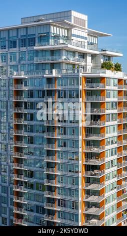 Eigentumswohnung oder Apartmentgebäude in der Innenstadt der Stadt. Außenansicht einer modernen mehrstöckigen Apartmentfassade, Fenster und Balkon Stockfoto