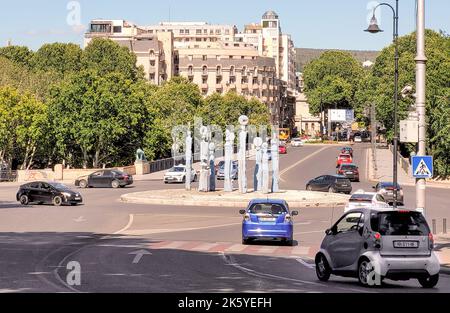 Tiflis, Georgien - 07 23 2022: Blick im Sommer entlang der Galaktion Tabidze Brücke mit der neunstelligen Statue von Uhren und Autos am Kreisverkehr. Der Stockfoto