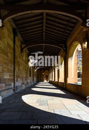 Säulen werfen Schatten in einer Arkade im Hauptquadrangle der Universität von Sydney Stockfoto