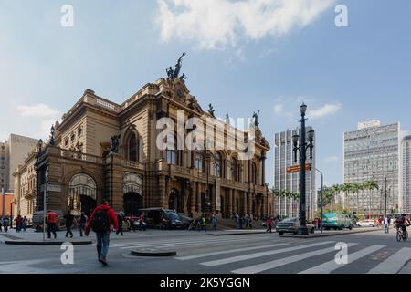 Sao Paulo, Brasilien. 16. Juni 2014. Passanten laufen am Theatro Municipal de Sao Paulo (Stadttheater von Sao Paulo) im Praca Ramos de Azevedo, im historischen Zentrum von Sao Paulo, vorbei, wie sie während des Fußballweltcupturniers in Brasilien gesehen wurden. Stockfoto