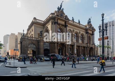 Sao Paulo, Brasilien. 16. Juni 2014. Passanten laufen am Theatro Municipal de Sao Paulo (Stadttheater von Sao Paulo) im Praca Ramos de Azevedo, im historischen Zentrum von Sao Paulo, vorbei, wie sie während des Fußballweltcupturniers in Brasilien gesehen wurden. Stockfoto