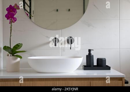 Modernes weißes Badezimmer mit schwarzen Armaturen und Accessoires. Stockfoto