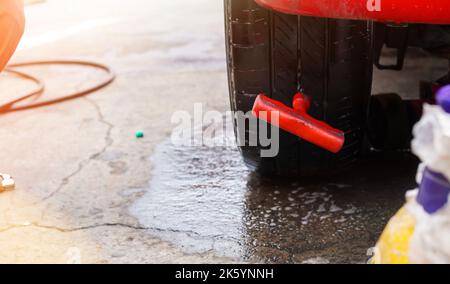 Jakarta, Indonesien 10. Oktober 2022 : Nahaufnahme Mechaniker Reifen aufblasen und Luftdruck mit Manometer Druck in der Tankstelle prüfen Stockfoto