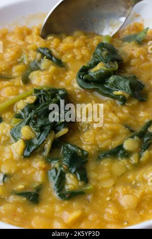 Nahaufnahme von Dhal- oder roten Linsen und Spinat-Kurvig oder Gericht mit einem Löffel, in Kokosmilch gekocht und temperiert, beliebte schnelle und gesunde Mahlzeit Stockfoto