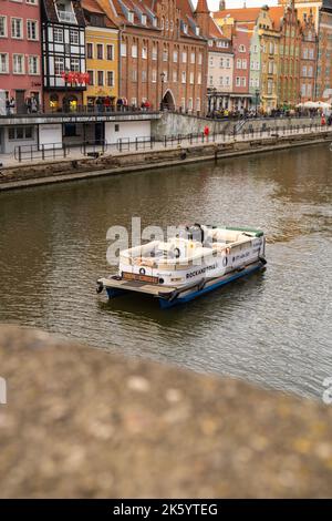 Danzig Polen Mai 2022 touristische Schifffahrt Altstadt in Danzig. Das Schiff mit Touristen fährt auf der Granary Island Reflection in Moltawa River Cityscap zu einer Kreuzfahrt am Flussufer ab. Uralter Kran. Besuchen Sie Danzig Poland Travel Destination. Touristenattraktion Stockfoto