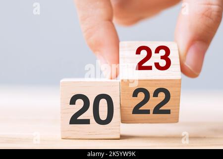 Hand Flip Cube Block 2022 bis 2023 Text auf Tisch. Auflösung, Überprüfung, Strategie, Endjahr, Ziel, Business- und Neujahrsferien Stockfoto