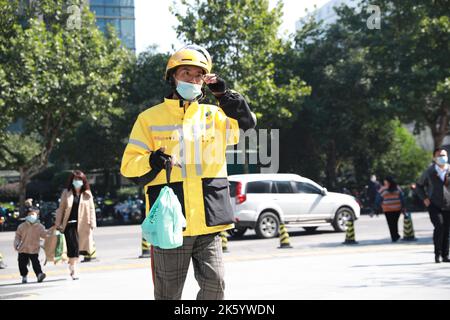 XI'AN, CHINA - 11. OKTOBER 2022 - Mitarbeiter holen Essen zum Mitnehmen von einem „Take-away-Schalter“ unter einem Bürogebäude in Xi'an, Provinz Shaanxi, Chin Stockfoto