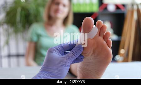 Orthopäde, die ein Korsett für Hallux Valgus bei weiblichen Patienten aufbringt Stockfoto