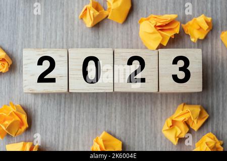 2023 Text Holzwürfel und zerbröckeltes Papier auf Holztischhintergrund. Neues Jahr Neue Ideen, Kreativ, Innovation, Phantasie, Inspiration, Auflösung, St Stockfoto