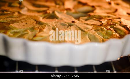 Apfelkuchen wird im Ofen auf einem Gericht gekocht. Der Prozess des Backens eines Apfelkuchen in einer Küche zu Hause Stockfoto