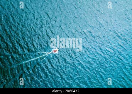 Olyka oder ein Schiff, das auf der Oberfläche des blauen, grenzenlosen Ozeans segelt, Luftaufnahme von oben. Stockfoto