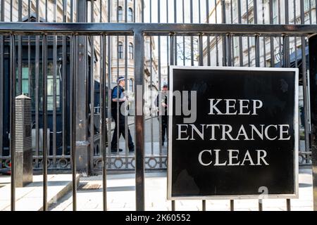 London, Großbritannien - 26. März 2022: Die Tore zur Downing Street, Whitehall, mit einem bewaffneten Polizeibeamten. 10 Downing Street ist die Heimat des Premierministers und der Nu Stockfoto