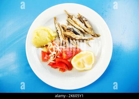 Frittierter Whitebait mit einer Seite Kartoffelpüree und Tomatensalat (selektiver Fokus) Stockfoto