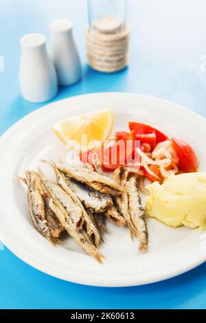 Frittierter Whitebait mit einer Seite Kartoffelpüree und Tomatensalat (selektiver Fokus) Stockfoto