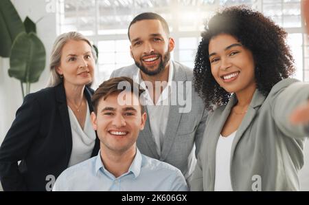 Porträt einer Gruppe von fröhlichen, vielfältigen Geschäftsleuten, die bei der Arbeit ein Selfie machen. Glückliche gemischte Rennen Geschäftsfrau, die ein Foto mit ihrem freudigen Stockfoto