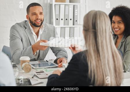 Junger, glücklicher Geschäftsmann mit gemischter Rasse, der einer kaukasischen Kollegin einen Bericht erstattet, während er bei einem Treffen am Arbeitsplatz zusammenkommt. Geschäftsfrau, die ein Stockfoto
