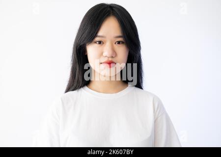 Schöne asiatische Frau. Perfekte Haut. Frischer Look. Natürliche Pflege. Ziemlich dunkelhaarige Dame rot Lippenstift isoliert weiß. Stockfoto