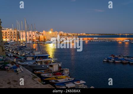 Gallipoli bei Nacht: Blick über den Fischerhafen und den Freizeitboothafen von der Altstadt von Gallipoli aus gesehen, Apulien (Apulien), Italien. Stockfoto