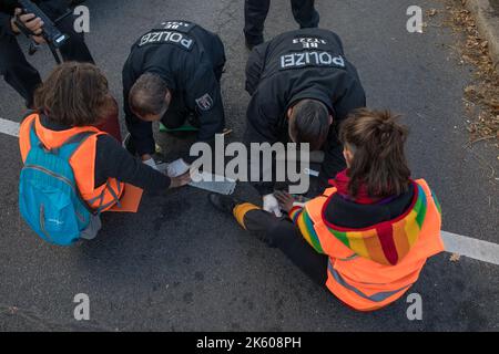 Berlin, Deutschland. 11. Oktober 2022. Klimaaktivisten der Gruppe Last Generation blockierten am 11. Oktober 2022 in Berlin den Verkehr. Mehrere Abfahrten der Berliner Autobahn A100 waren betroffen. Dies verursachte viele Staus. Zahlreiche Menschen waren darüber sehr verärgert. Ein Mann goss eine Flüssigkeit über die Klimaaktivisten. (Foto: Michael Kuenne/PRESSCOV/Sipa USA) Quelle: SIPA USA/Alamy Live News Stockfoto