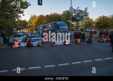 Berlin, Deutschland. 11. Oktober 2022. Klimaaktivisten der Gruppe Last Generation blockierten am 11. Oktober 2022 in Berlin den Verkehr. Mehrere Abfahrten der Berliner Autobahn A100 waren betroffen. Dies verursachte viele Staus. Zahlreiche Menschen waren darüber sehr verärgert. Ein Mann goss eine Flüssigkeit über die Klimaaktivisten. (Foto: Michael Kuenne/PRESSCOV/Sipa USA) Quelle: SIPA USA/Alamy Live News Stockfoto