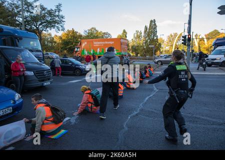 Berlin, Deutschland. 11. Oktober 2022. Klimaaktivisten der Gruppe Last Generation blockierten am 11. Oktober 2022 in Berlin den Verkehr. Mehrere Abfahrten der Berliner Autobahn A100 waren betroffen. Dies verursachte viele Staus. Zahlreiche Menschen waren darüber sehr verärgert. Ein Mann goss eine Flüssigkeit über die Klimaaktivisten (Foto: © Michael Kuenne/PRESSCOV via ZUMA Press Wire) Stockfoto