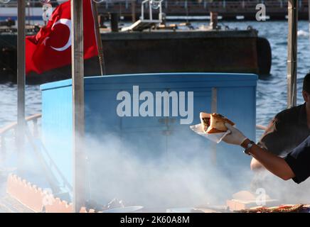 Eminonu, Istanbul, Türkei. Fisch und Brot im Boot. Stockfoto