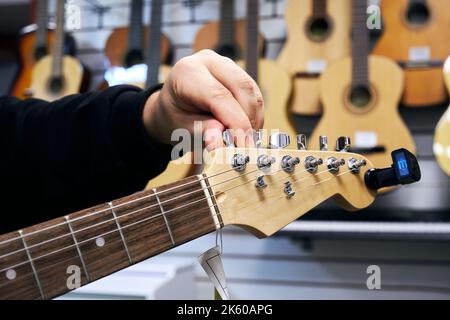 E-Gitarren-Tuning in einem Musikgeschäft Stockfoto